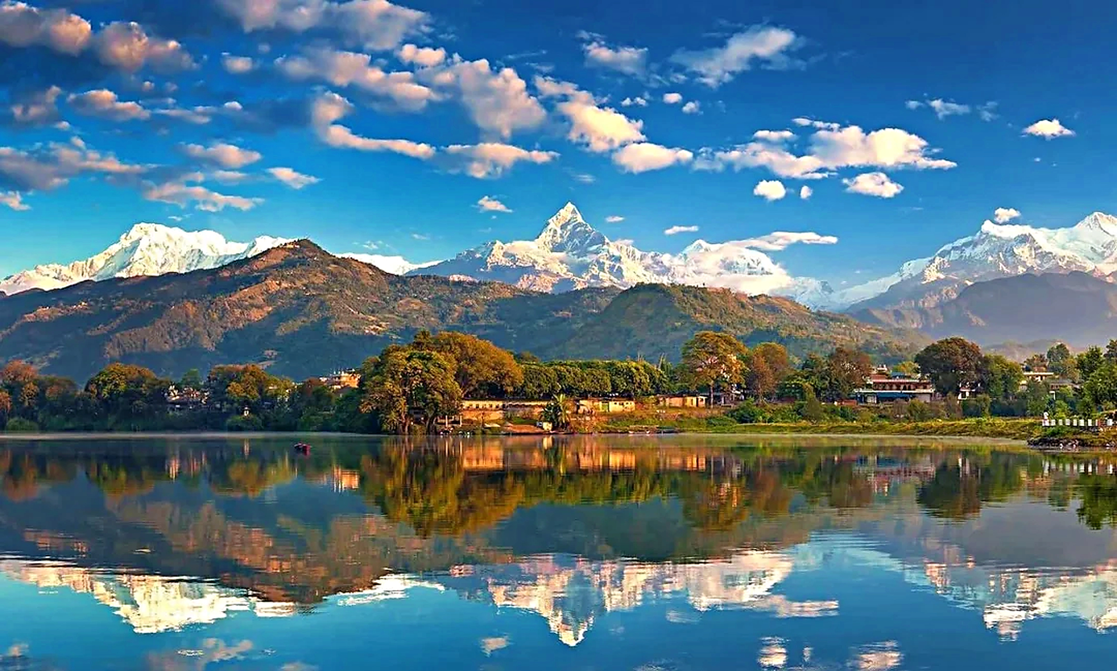 Machhapuchhre Fishtail peak reflected in mirror-calm waters of Phewa Lake at dawn